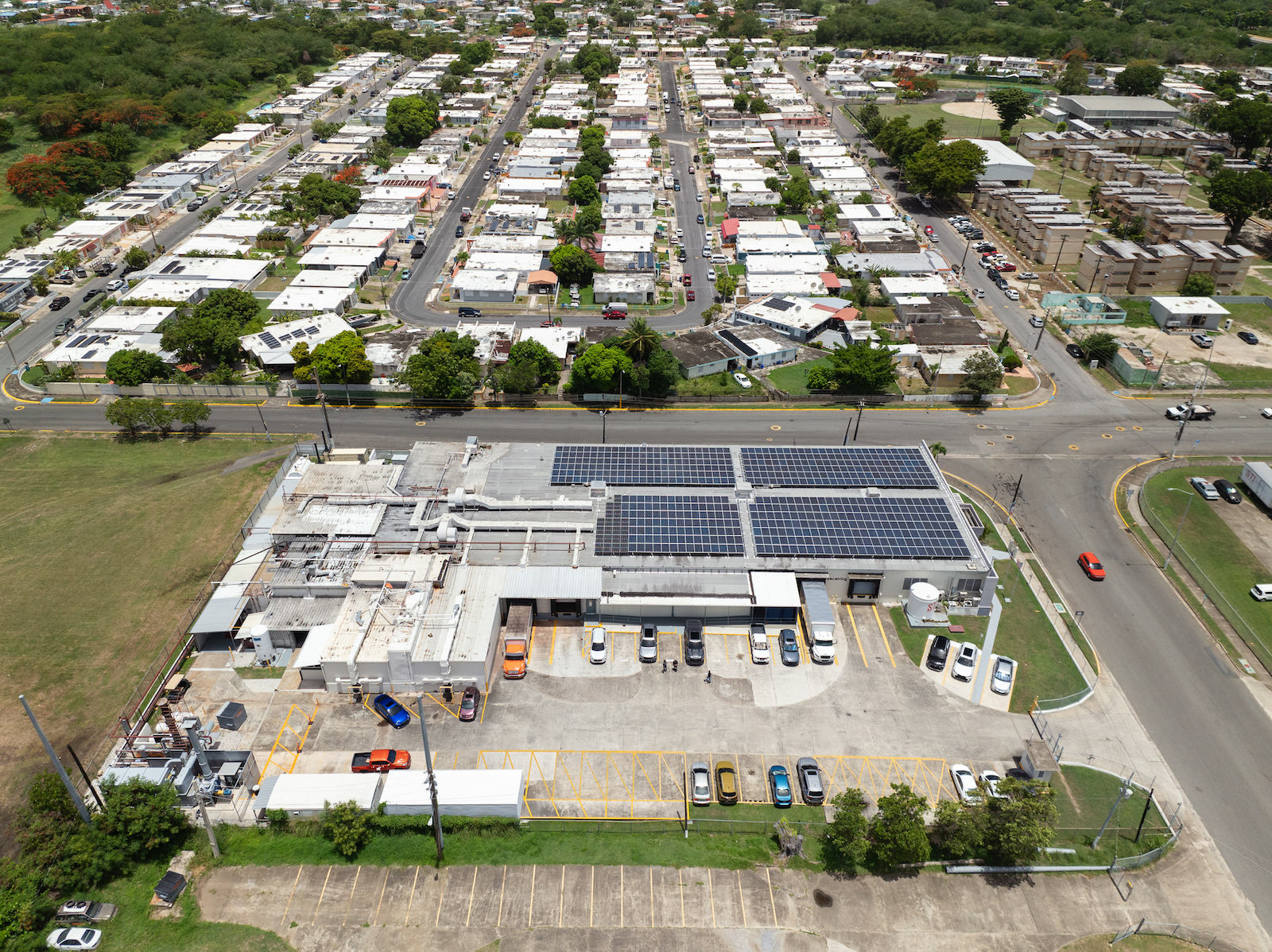 An aerial shot of a large industrial plant and warehouse very close to a neighborhood with residential houses