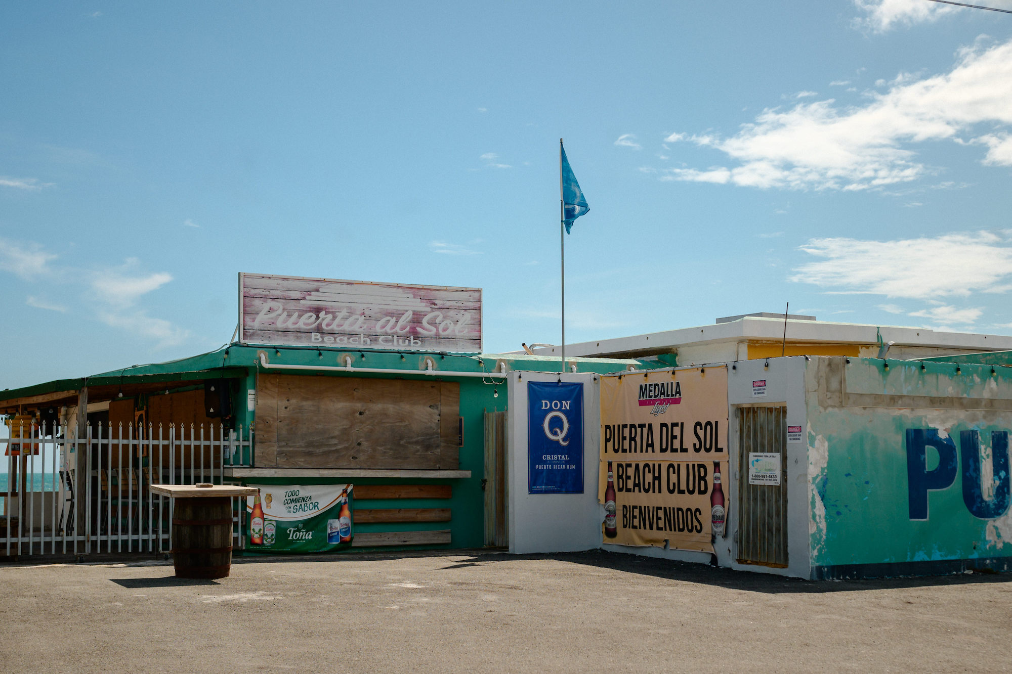 Restaurants with signs but closed windows under a blue sky