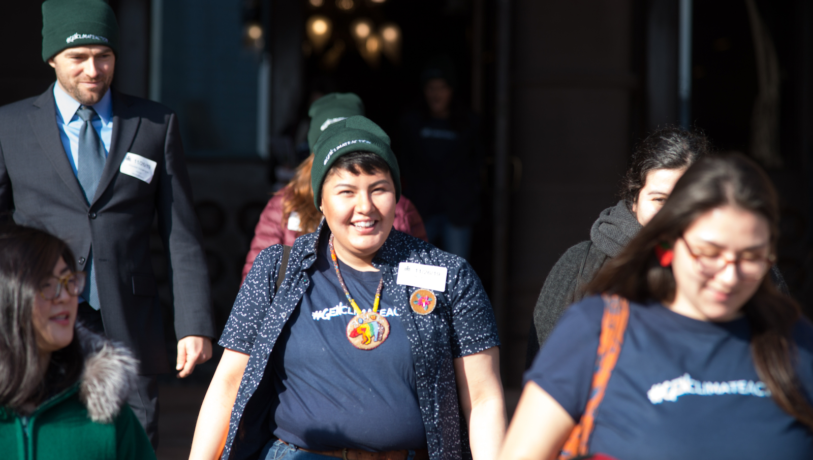 Beze Gray, a plaintiff in a climate lawsuit against Ontario, walks wearing a hat and t-shirt.