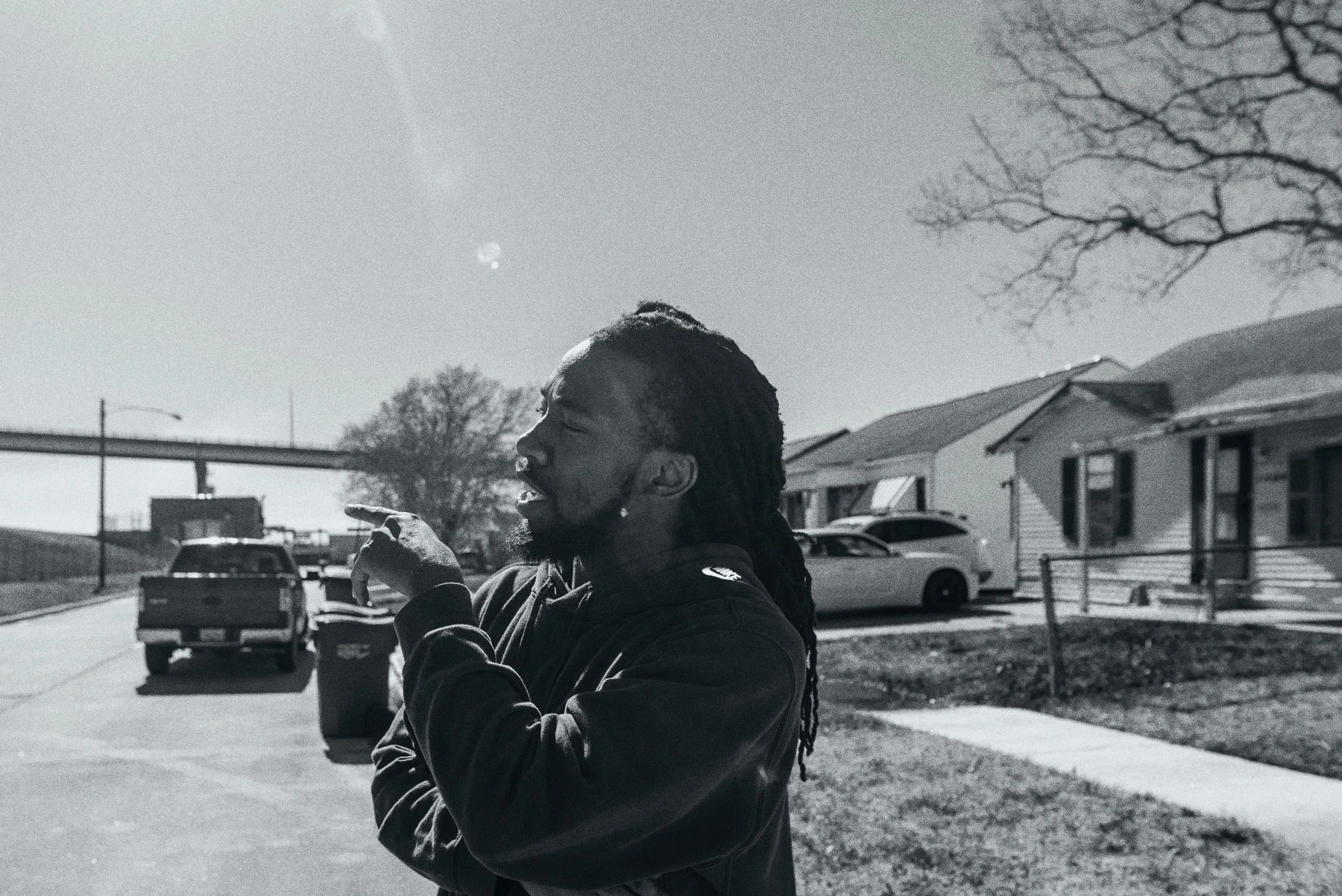 a man stands in a neighborhood and points off to the left